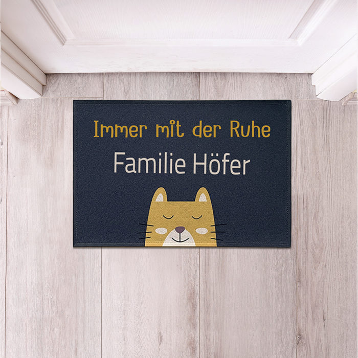 schwarze fußmatte mit dem text immer mit der ruhe und einer gelassenen comickatze darauf. personalisierbar